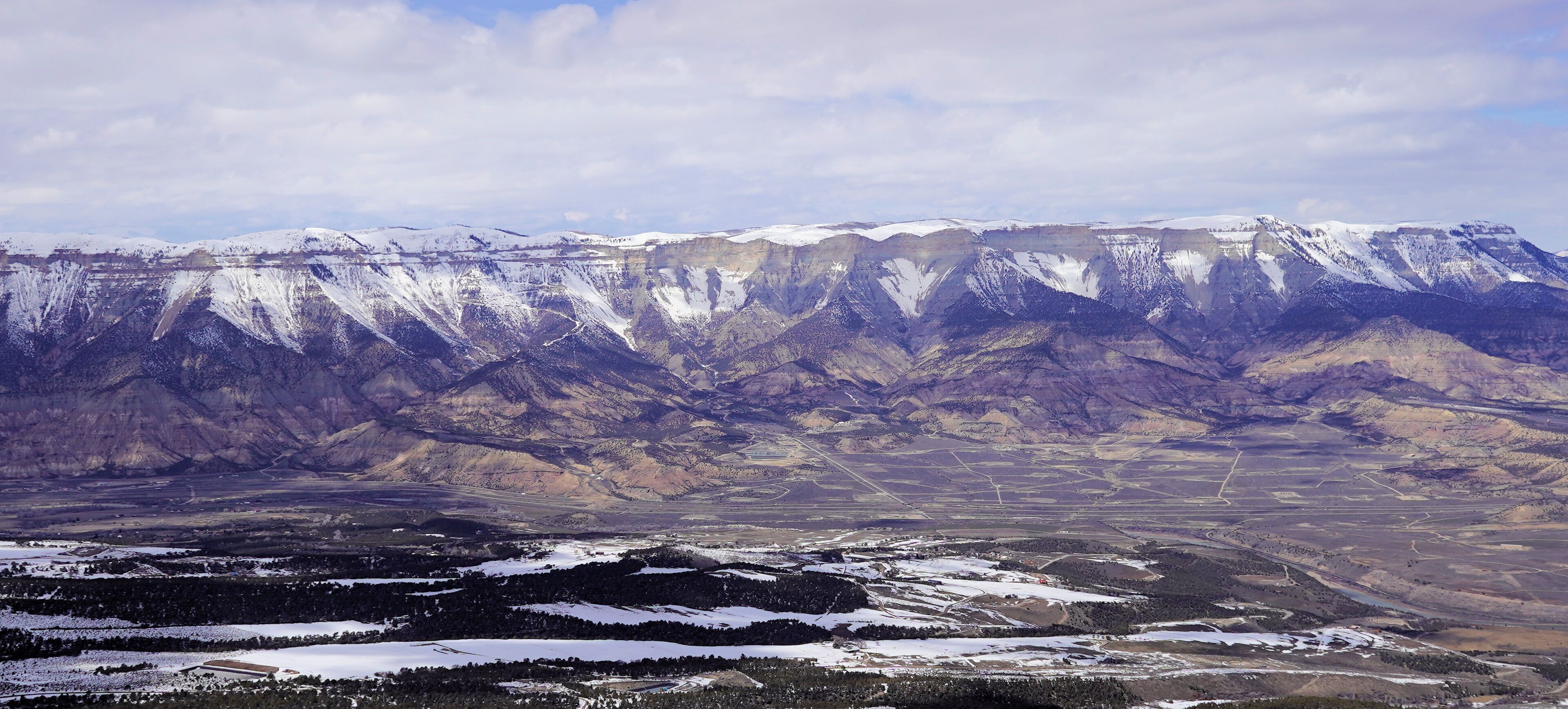 A snow-covered mountain range with a valley below.