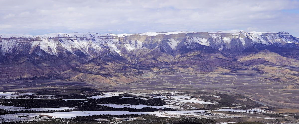A snow-covered mountain range with a valley below.