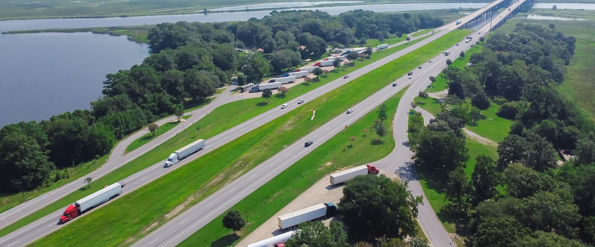 A highway with multiple lanes, a bridge, and a large body of water.