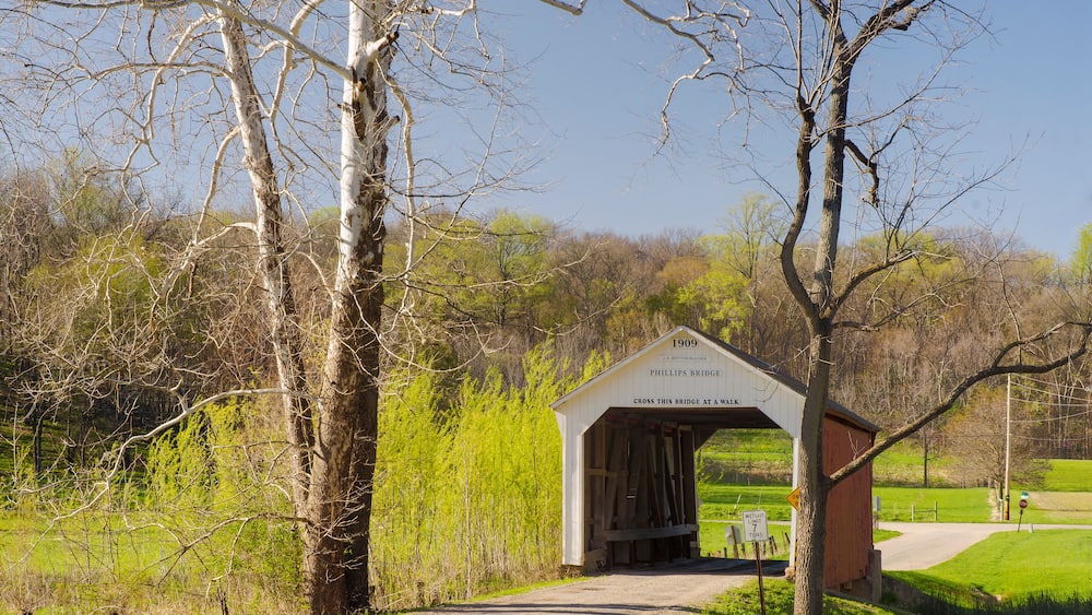 A covered bridge with a sign reading '1909 PHILLIPS BRIDGE' and a 'No Parking' sign.