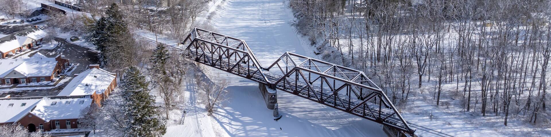 Pittsford, NY, USA - 02-01-2025: Winter afternoon aerial photo of the Village of Pittsford Schoen Place and the Erie Canal with snow on the ground.