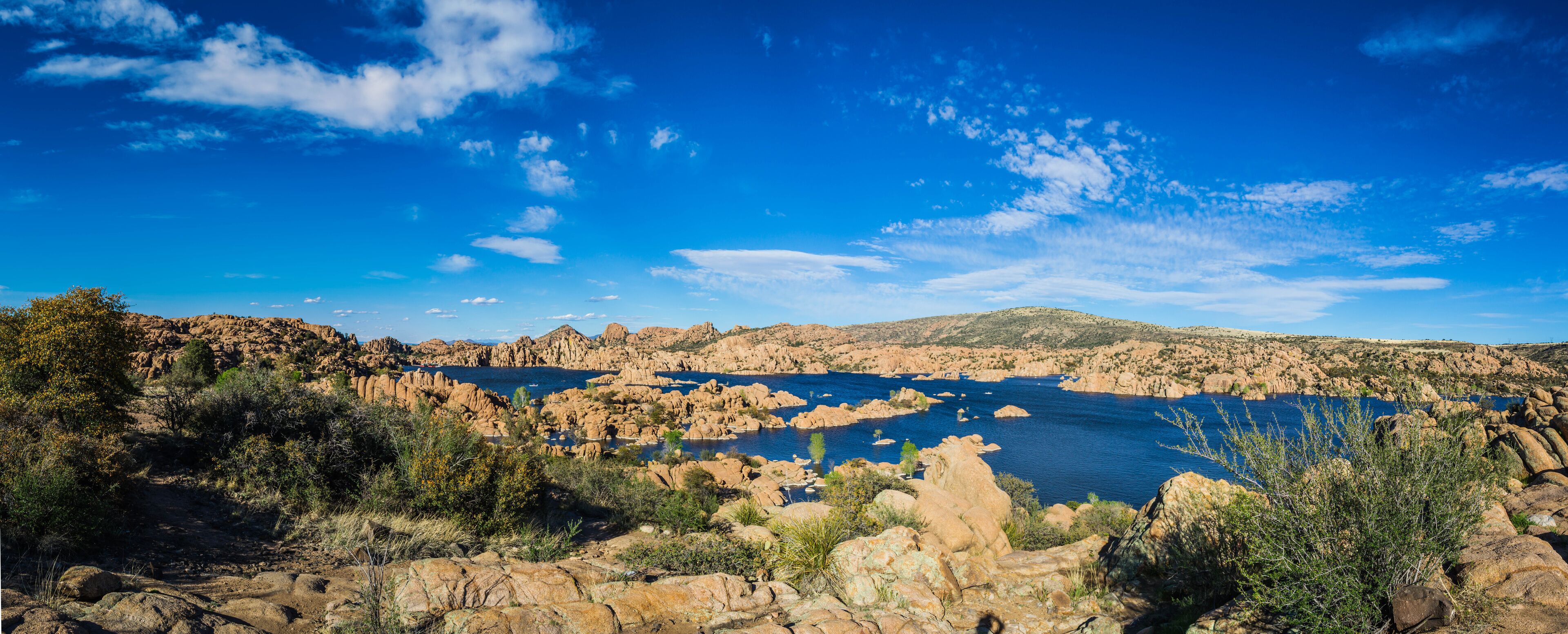 Panorama of the rugged beauty of Watson Lake in Prescott Arizona.  This reservoir is surrounded be weathered cliffs of the Granite Dells and blear blue skies.