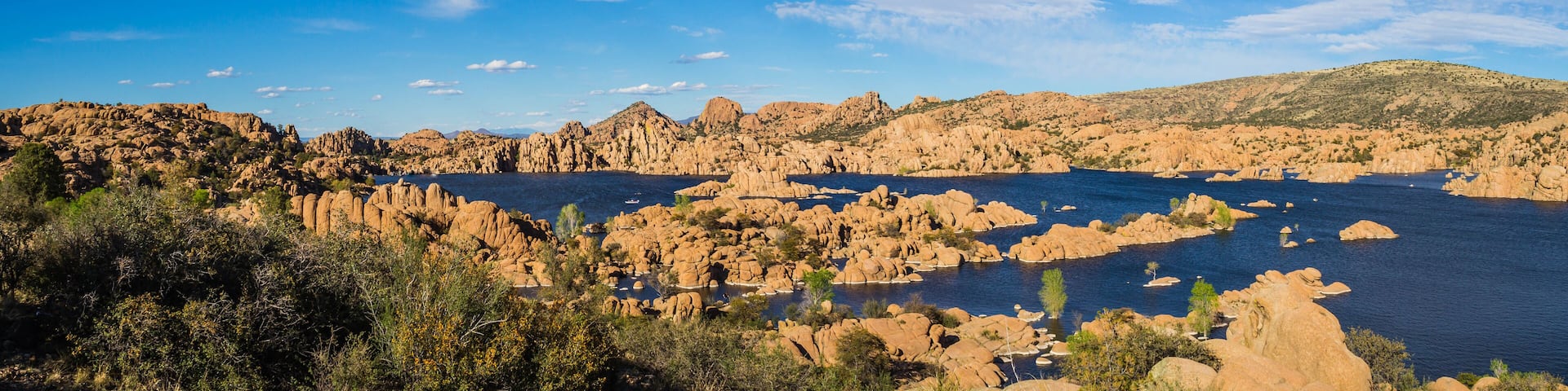 Panorama of the rugged beauty of Watson Lake in Prescott Arizona. This reservoir is surrounded be weathered cliffs of the Granite Dells and blear blue skies.