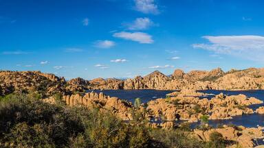 Panorama of the rugged beauty of Watson Lake in Prescott Arizona. This reservoir is surrounded be weathered cliffs of the Granite Dells and blear blue skies.