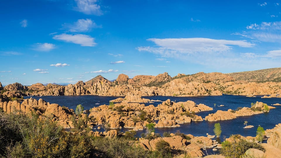A rocky landscape with a large body of water surrounded by hills and sparse vegetation.
