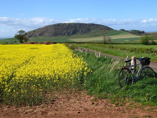 The road to Traprain The road out of Papple that heads towards Whittinghame. In the background Traprain Law dominates the view. It has been occupied/used from Neolithic times, through the Bronze age(when it was used for burials), Iron ages up through Roman to about 5th century AD. There are remains of an ancient fort on the top.