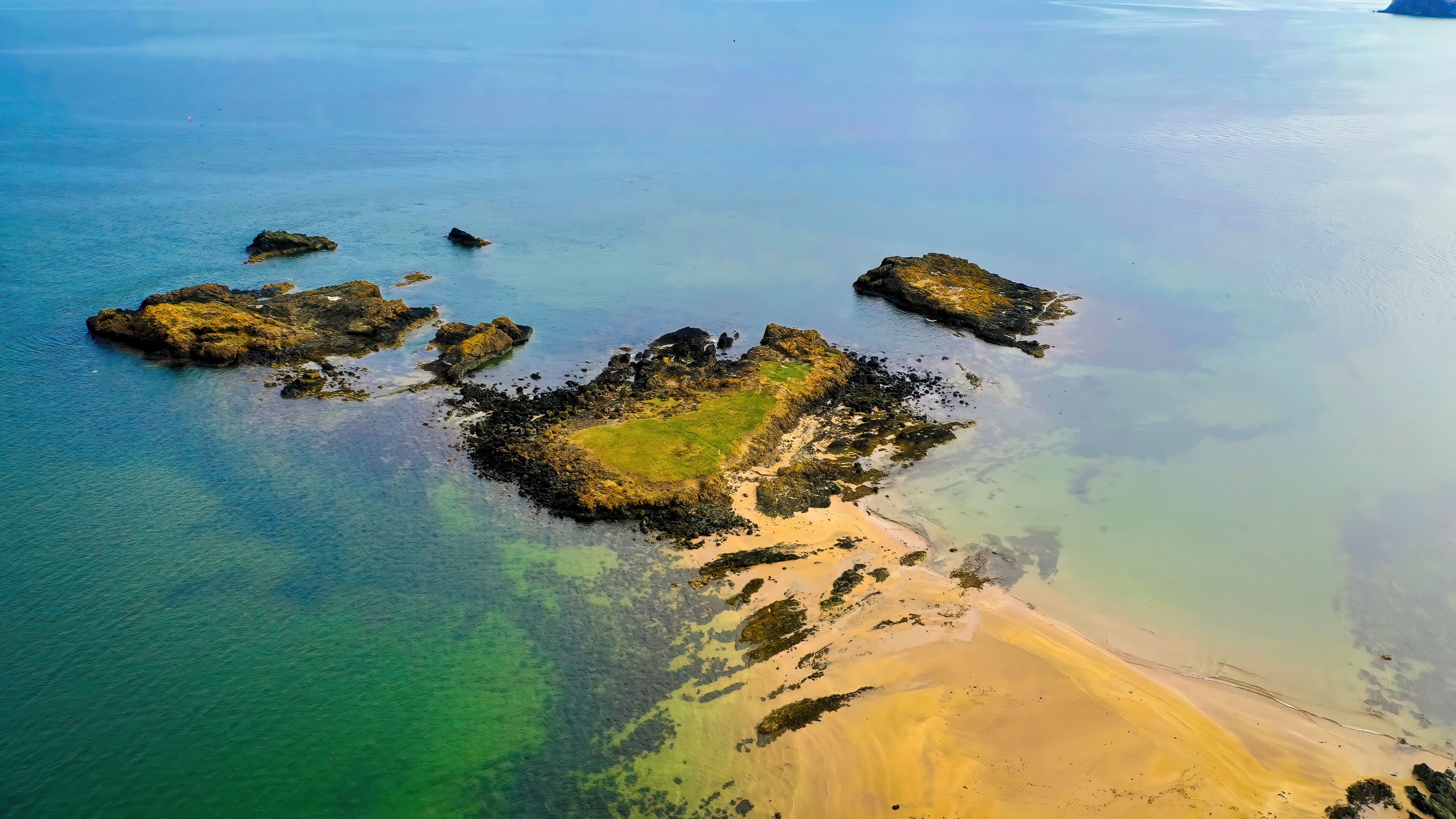 Aerial view of Daisy Island with rock formations and clear water, North Berwick, Scotland.