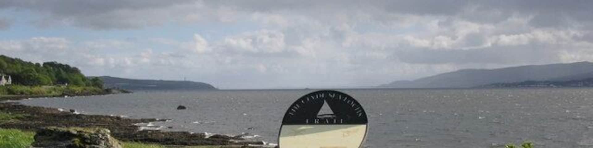 Cove Green. A view looking south down Loch Long from the picnic area on Cove Green, towards Cloch Point (left) and Dunoon (right). An information plaque for the Clyde Sea Lochs Trail can be seen in the foreground.
