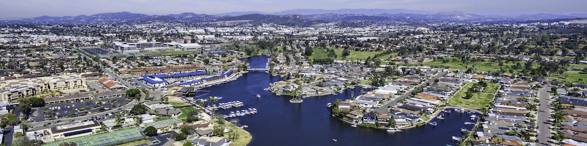 Vue aérienne d’une ville avec une rivière, des bateaux et des quartiers résidentiels.