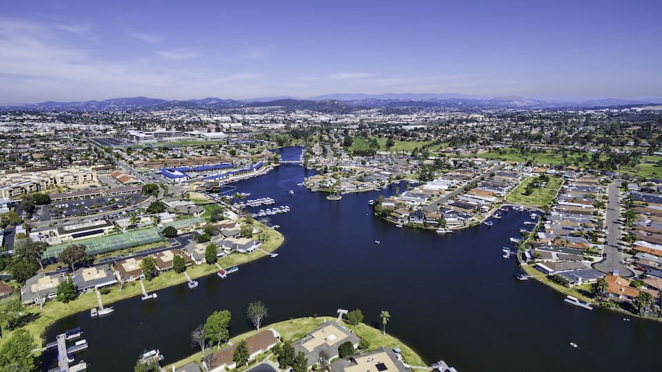 An aerial view of a city with a river, boats, and residential areas.