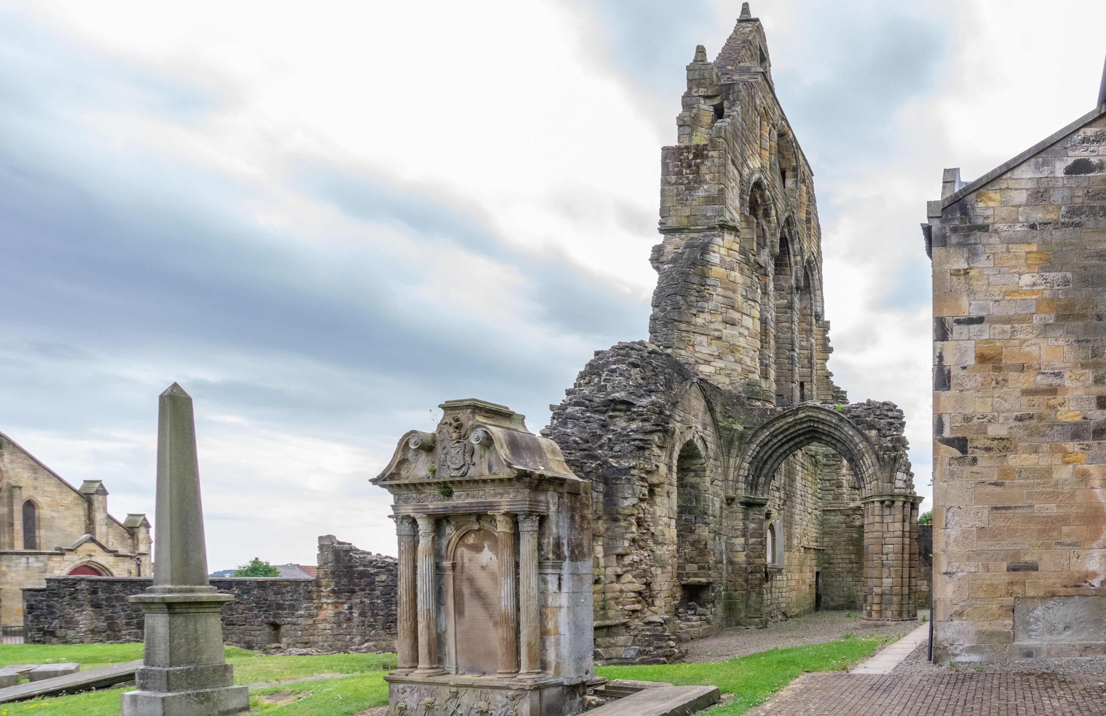 An ancient stone church with a tall, pointed tower and a large arched doorway.