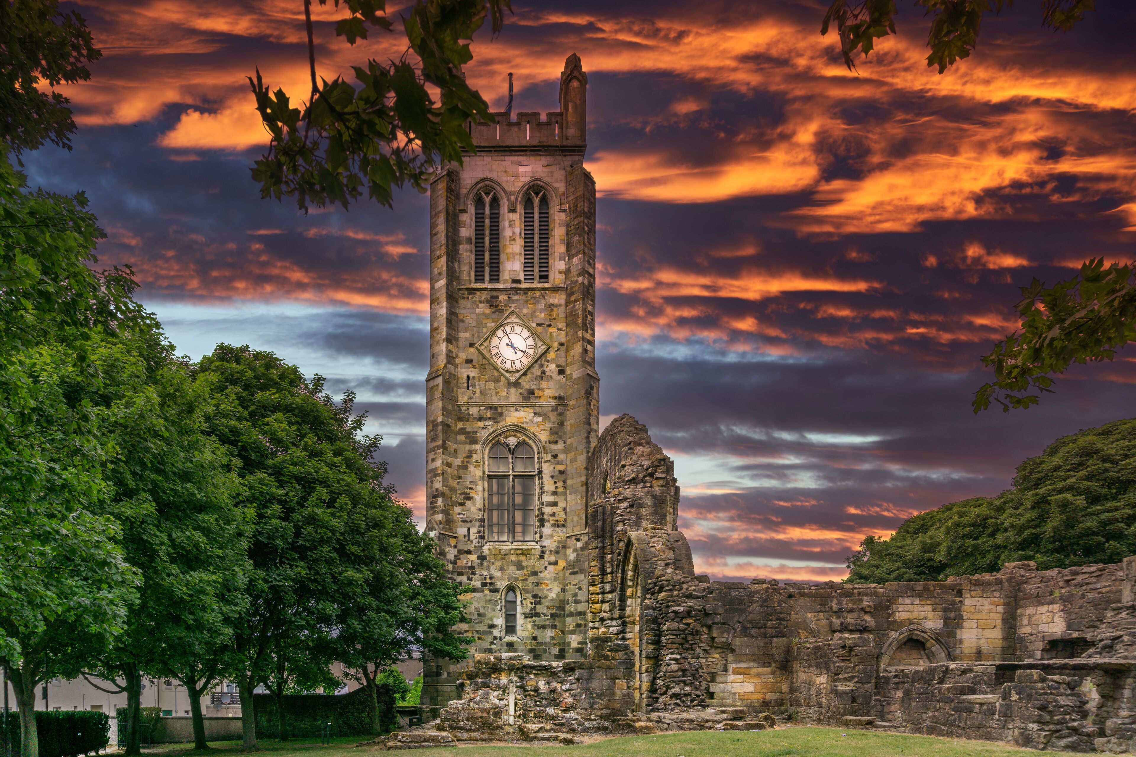 The Old Clock Tower Ruins at KIlwinning Abbey at the end of the day in front of a dramatic red Sky.