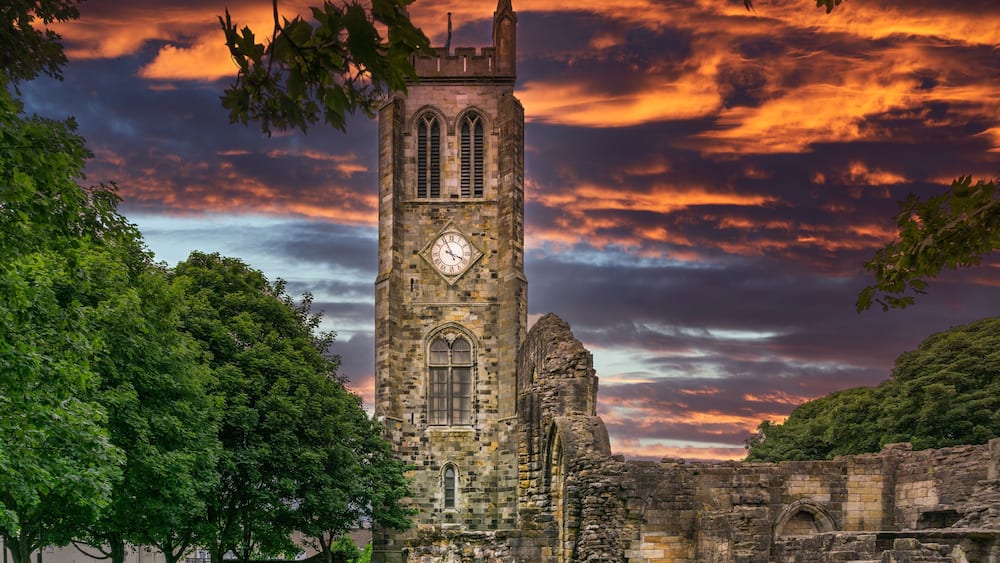 The Old Clock Tower Ruins at KIlwinning Abbey at the end of the day in front of a dramatic red Sky.