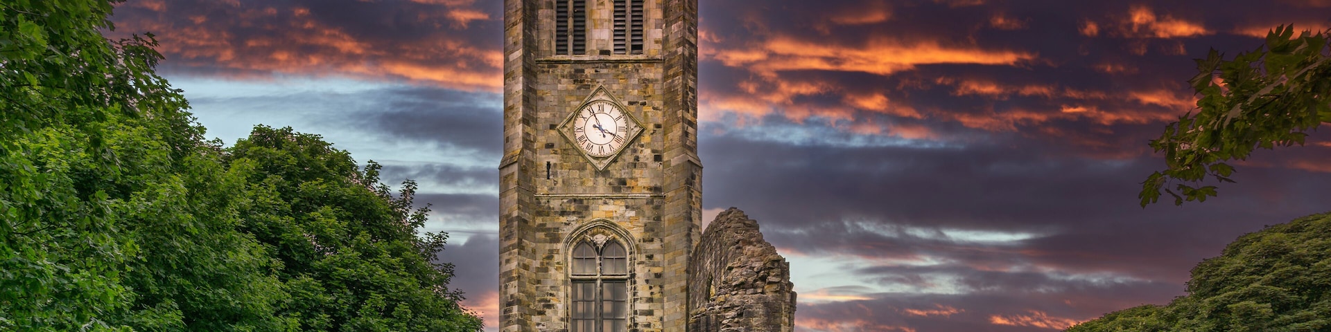 The Old Clock Tower Ruins at KIlwinning Abbey at the end of the day in front of a dramatic red Sky.