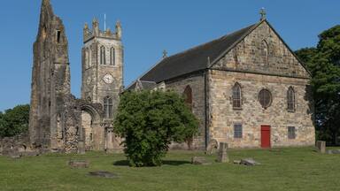 An old church with a clock tower and a red door.