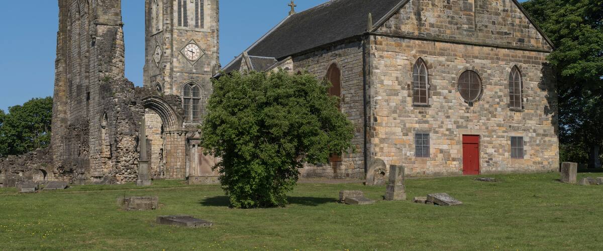 An old church with a clock tower and a red door.