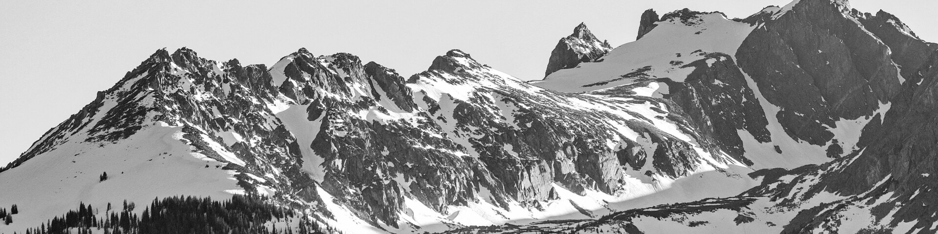 Cordillera nevada con un valle cubierto de bosque.