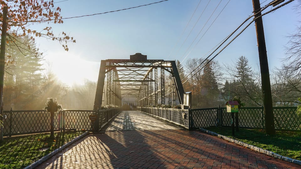 A metal bridge with a sign that reads 'Thank You' and a birdhouse on the right.