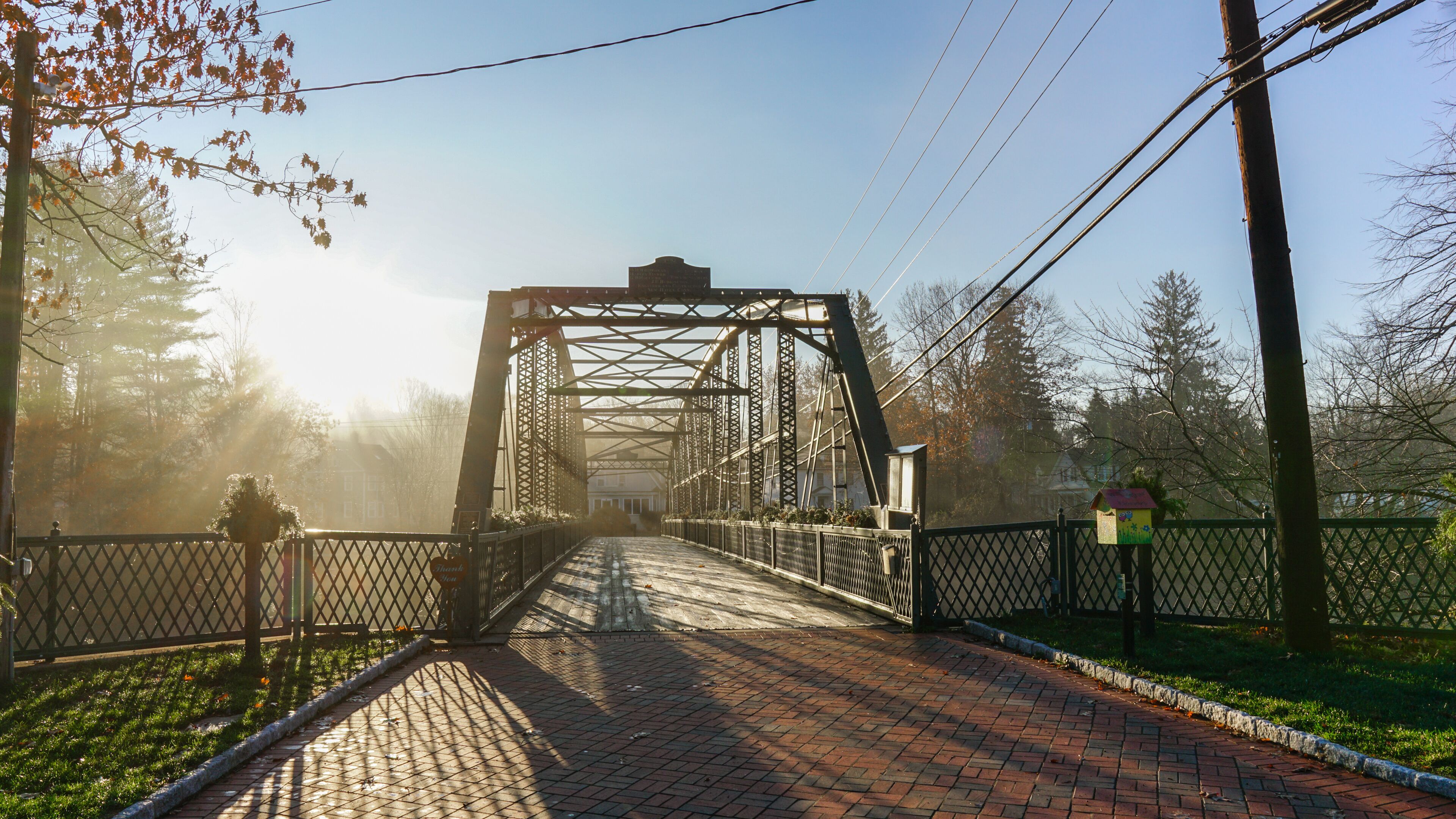 A metal bridge with a sign that reads 'Thank You' and a birdhouse on the right.