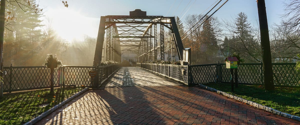 A metal bridge with a sign that reads 'Thank You' and a birdhouse on the right.