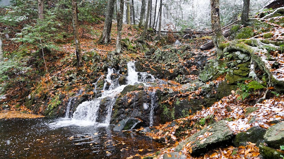 Northgate Falls in Simsbury Connecticut. A beautiful autumn waterfall spills into a stream.