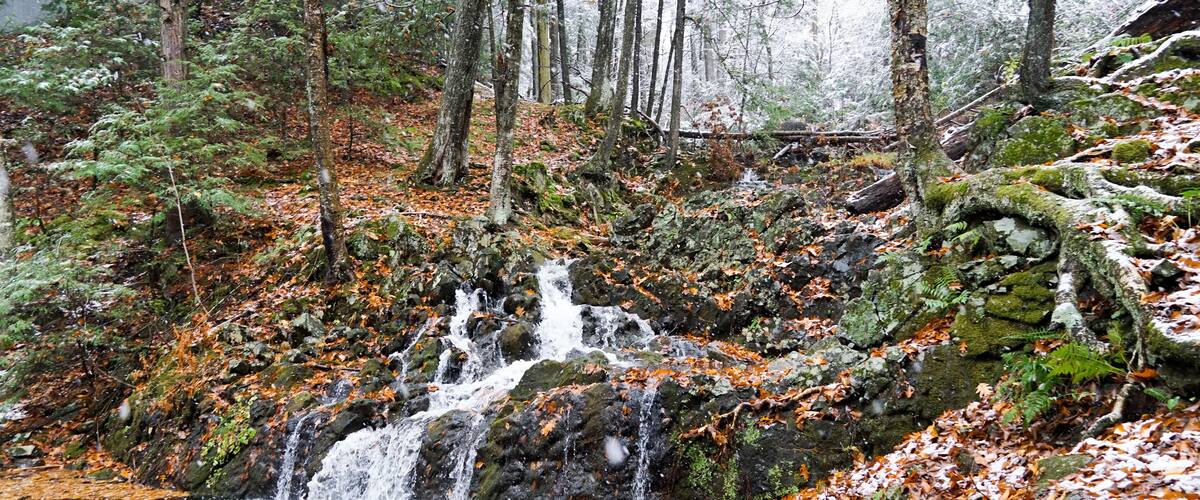 Northgate Falls in Simsbury Connecticut. A beautiful autumn waterfall spills into a stream.