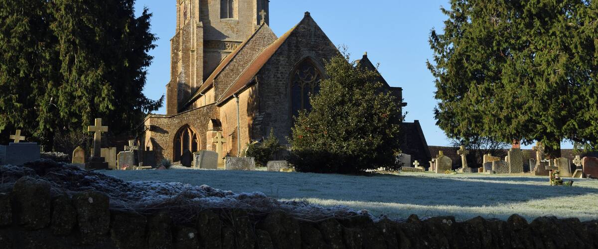 A church with a tall tower and a stone building.