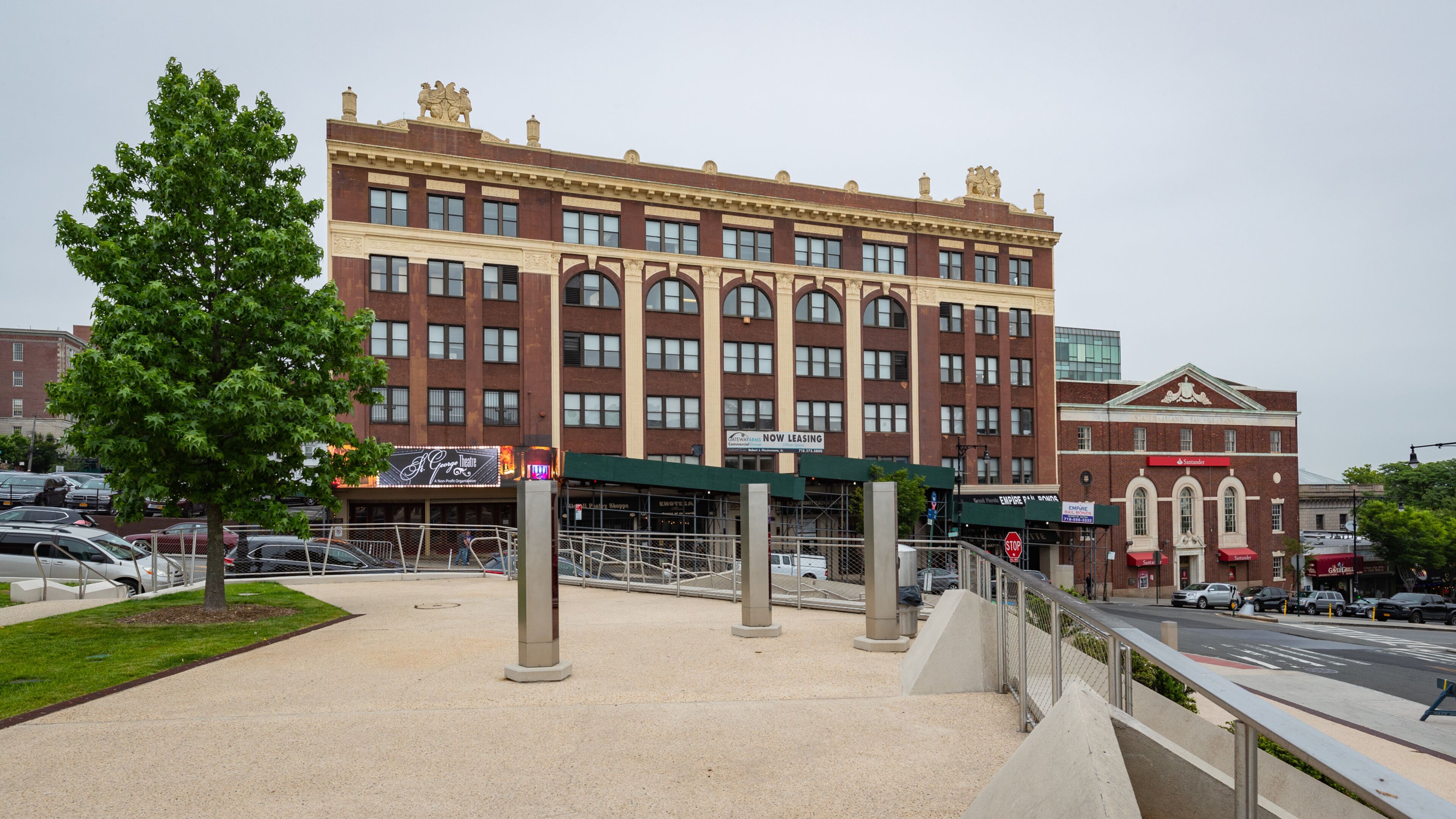 A large brick building with arched windows and a green awning.