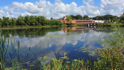 Clouds and sky reflect on the still waters of the Yahara River in Stoughton, Wisconsin.