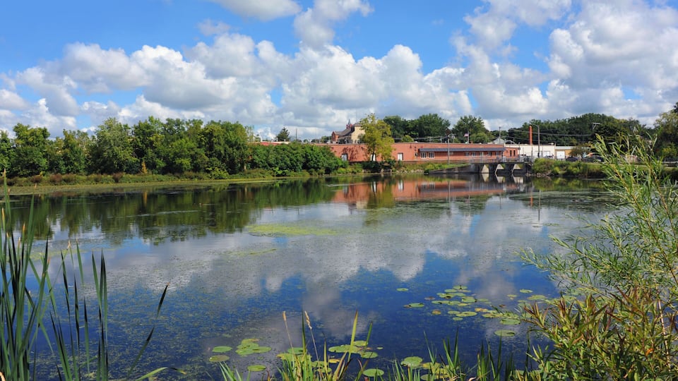 Clouds and sky reflect on the still waters of the Yahara River in Stoughton, Wisconsin.