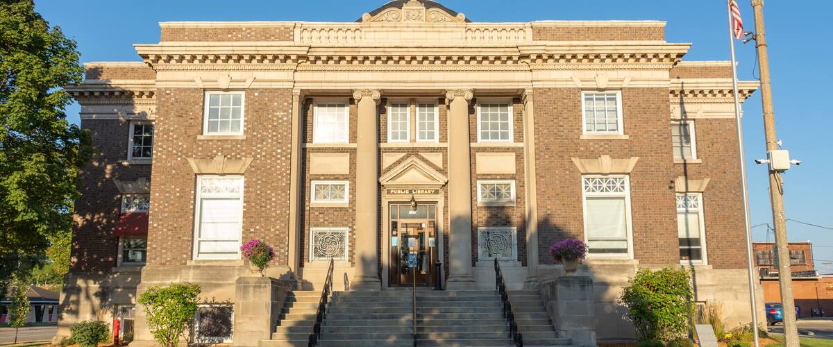 A public library with a brick facade, large windows, and a central entrance.