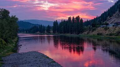 The sun sets over the Clark Fork River in the town of Superior, Montana, USA