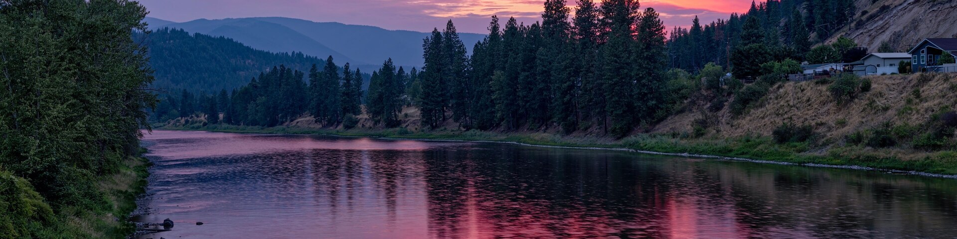 The sun sets over the Clark Fork River in the town of Superior, Montana, USA