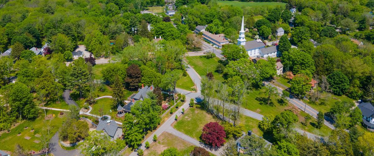 A lush green landscape with a prominent church featuring a tall steeple.