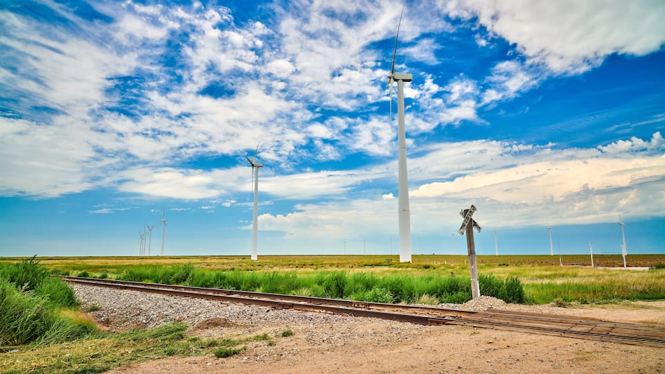 A railway track with wind turbines in the background.