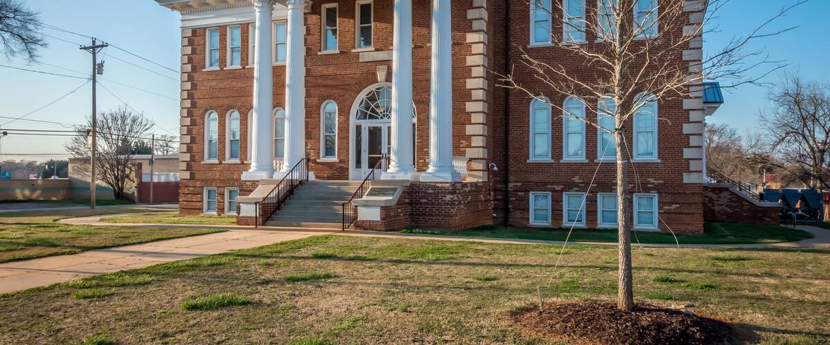 A large brick building with white columns and a central entrance.