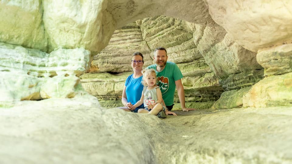 A family sitting in a natural rock formation.
