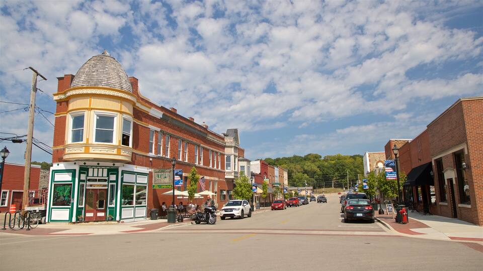 A street lined with historic buildings, a pub, and a few parked cars.