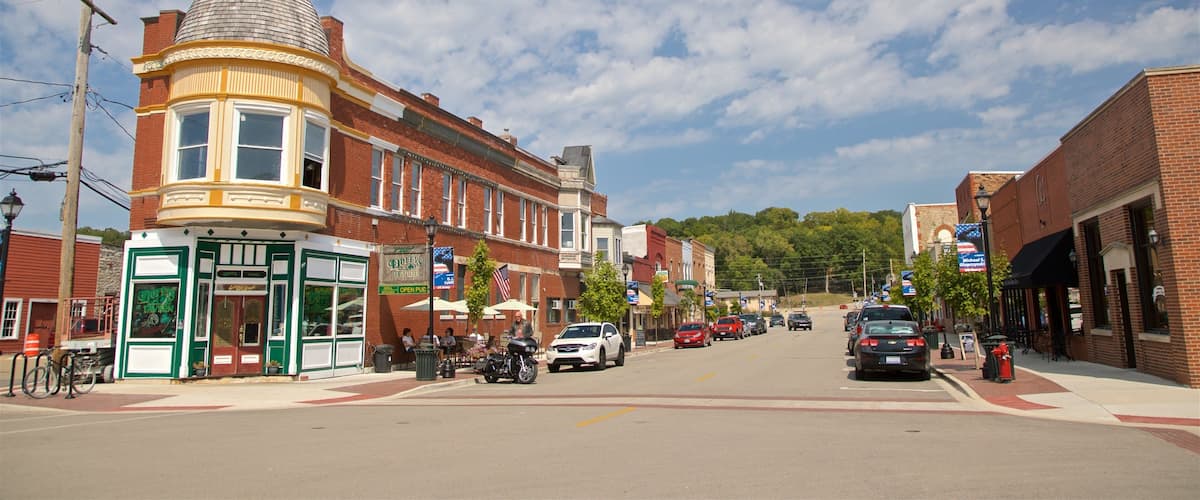 A street lined with historic buildings, a pub, and a few parked cars.