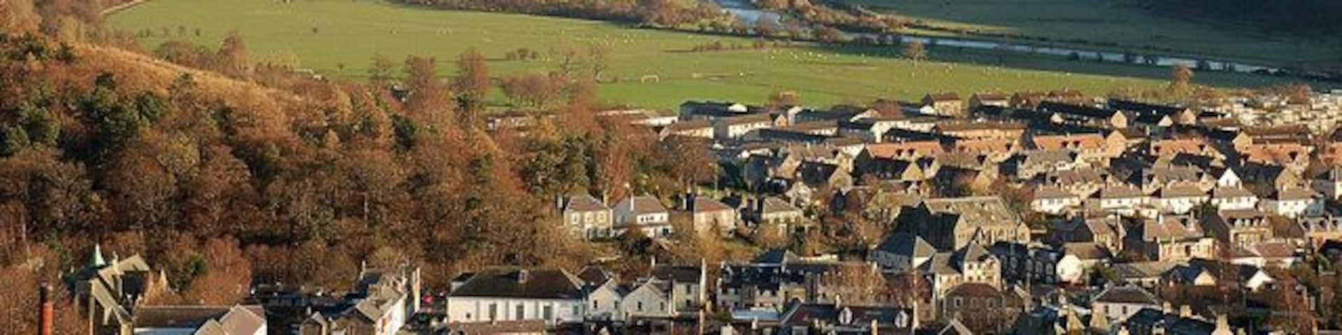 A valley with a river, a town, and surrounding hills.