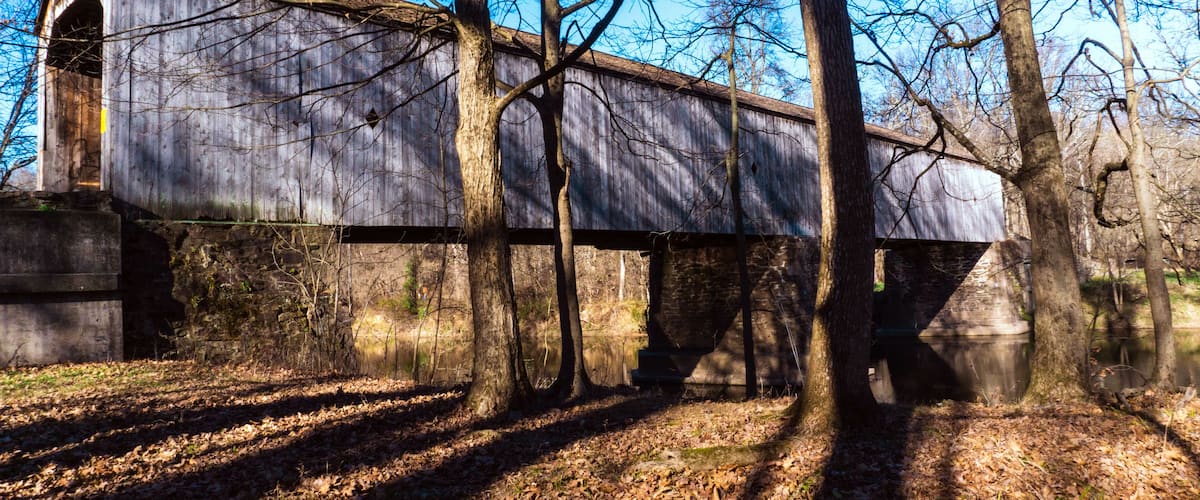 A covered bridge in a wooded area.
