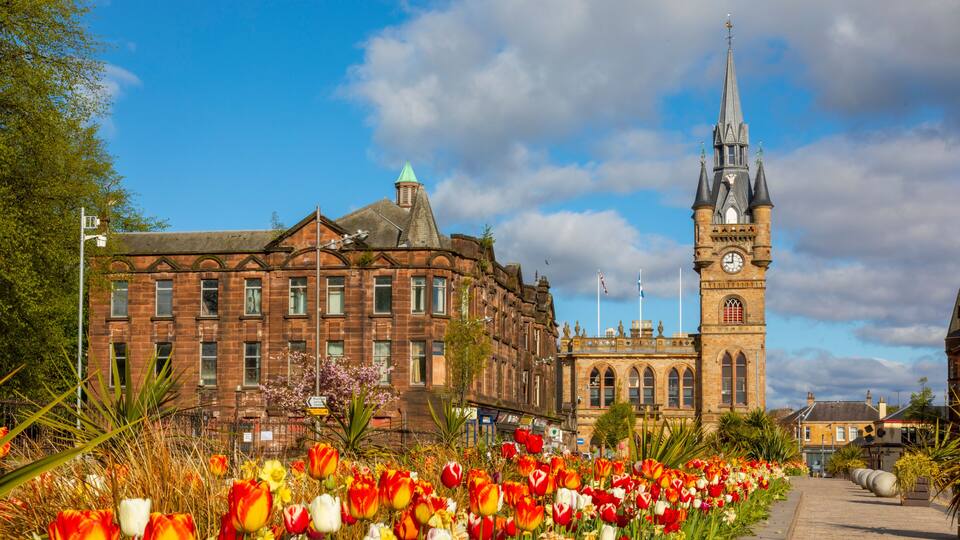 A historic building with a clock tower, surrounded by a vibrant tulip garden.