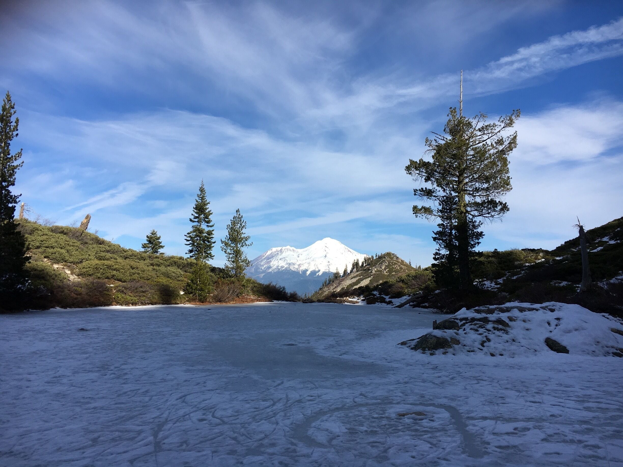 A snow-covered landscape with a mountain in the background.