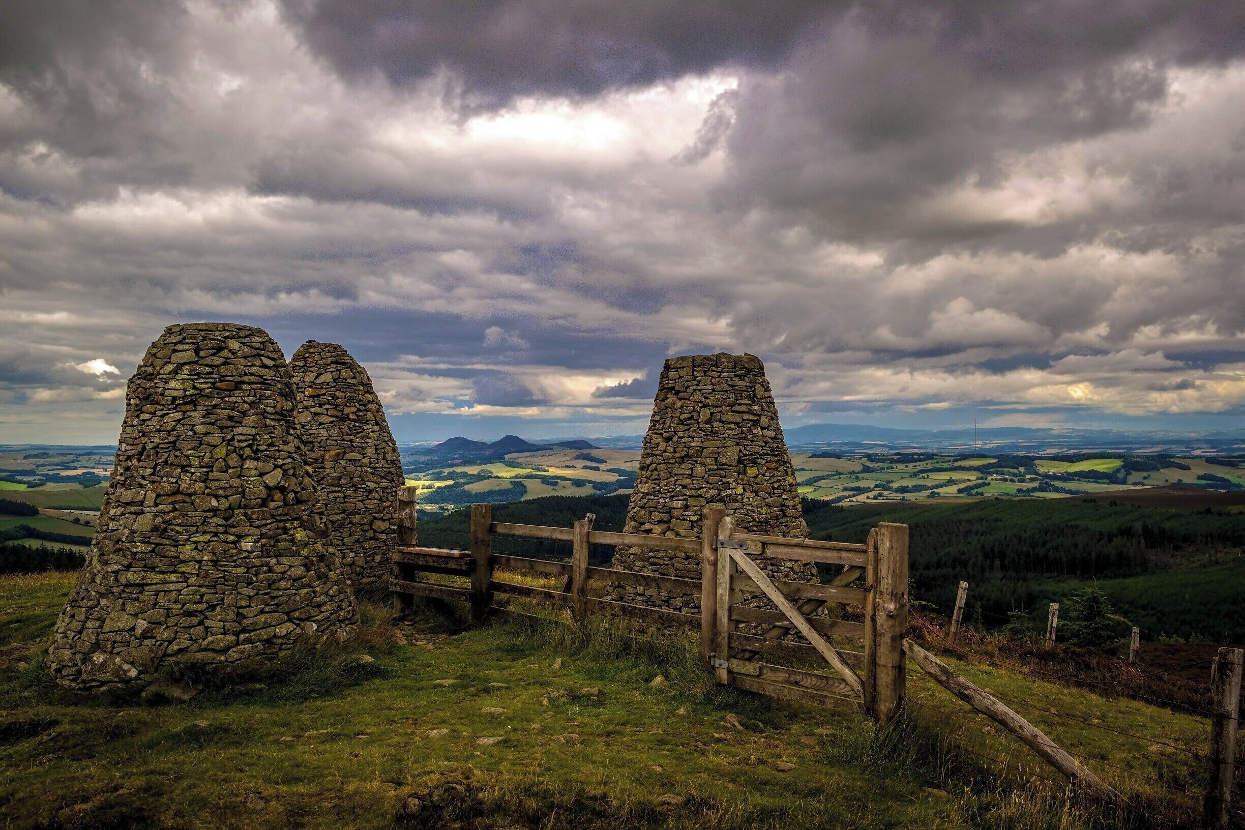 The Three Brethren are 3 large stone cairns, pictured here with the 3 peaks of Eildon Hill in the background. They have been on a hill outside Selkirk since the 16th century when they marked the meeting point of the lands of the Lairds of Yair, Philiphaugh and Selkirk.
