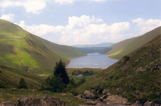 A lake surrounded by green hills.