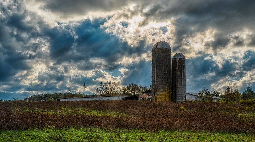 Two silos in a field on a farm on a stormy day