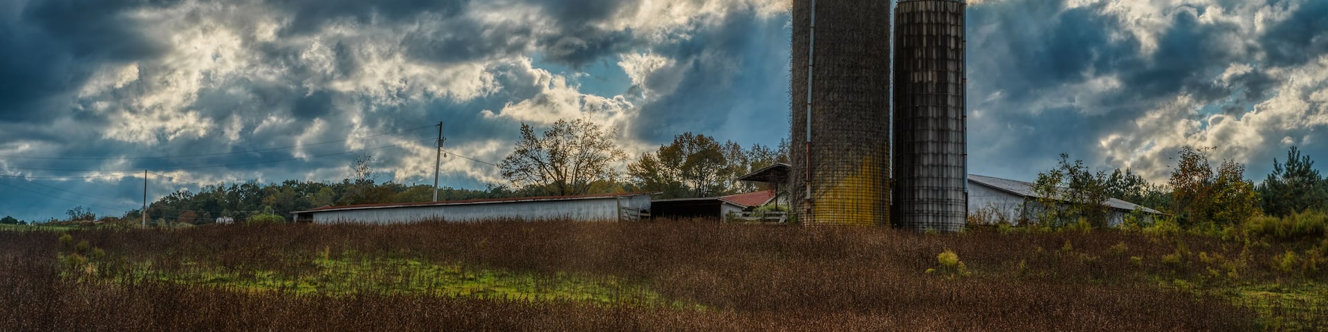 Two silos in a field on a farm on a stormy day