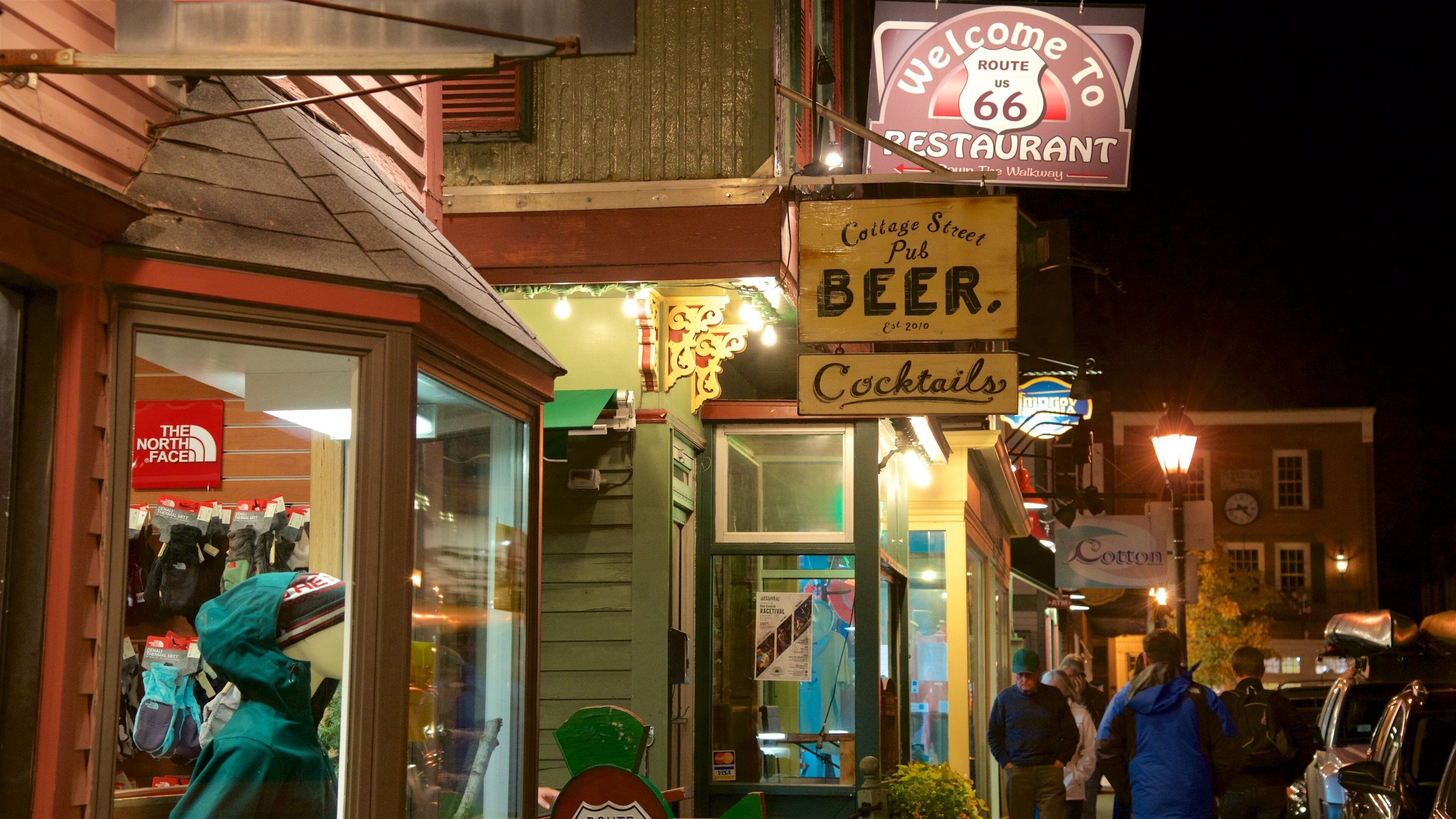 Bar Harbor que incluye escenas nocturnas y señalización y también un grupo pequeño de personas