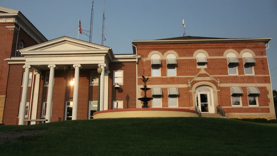 A large brick building with columns and a flagpole.
