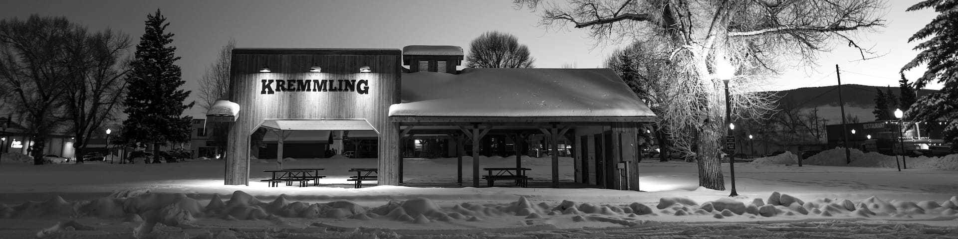 A snow-covered outdoor area with a building labeled 'KREMLING' and picnic tables.